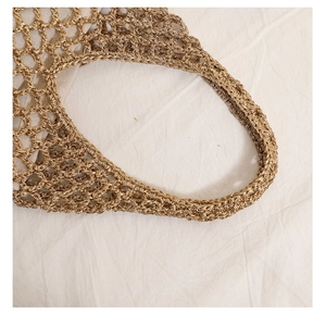Detail of champagne gold woven straw bag featuring hollow mesh and light fabric lining