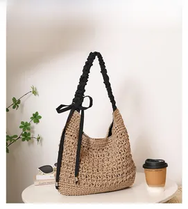 Détail du sac cabas en paille tissé avec bretelles à volants noires et noeud décoratif
