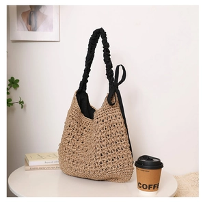 Détail du sac cabas en paille tissé avec anse froncée noire et nœud décoratif