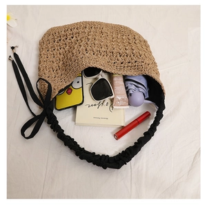 Vue intérieure du sac en paille montrant sa grande capacité pour lunettes et accessoires