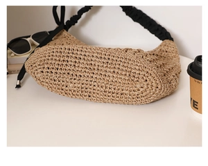 Détail du sac hobo en paille tissée avec bandoulière à volants noirs et nœuds latéraux