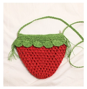 Detailed macro view of the handmade strawberry crochet bag with zipper and woven straps