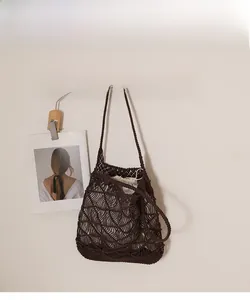 Detail of dark brown woven shoulder bag with hollow wavy pattern and drawstring liner