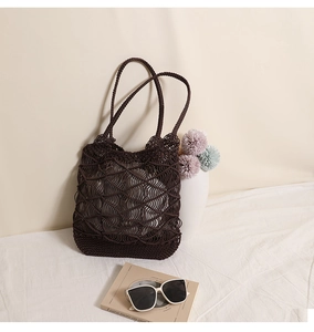 Detail of dark brown woven shoulder bag with bohemian hollow pattern and braided handles
