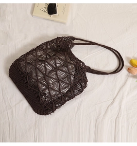 Detail of dark brown mesh woven tote bag with hollow wave texture on white fabric
