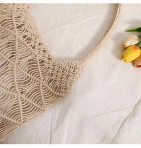 Close-up of beige straw woven bag showing intricate hollow pattern and wheat texture