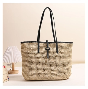 Details der Strohtasche mit eleganten schwarzen Lederriemen und Schnallendekor