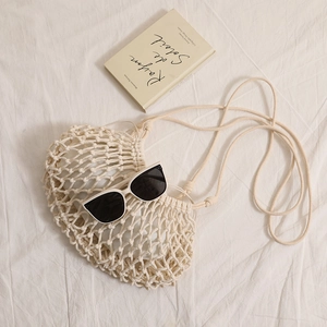 Minimalist beige crochet crossbody bag with mesh weave and cotton strap for beach vacations