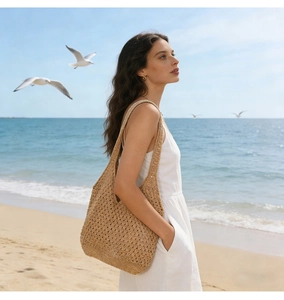 Casual straw tote bag with crochet hollow knit design for beach vacation on seaside background
