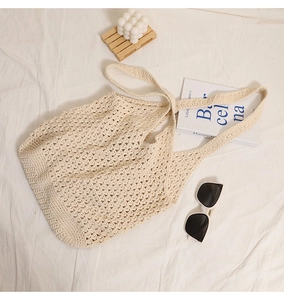 Detail of hollow mesh crochet tote bag with lifestyle accessories for summer vacations