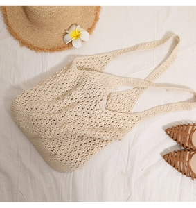 Detail of hollow knit cotton bag with casual straw hat and beach accessories