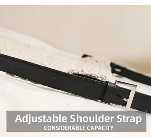 Détail de la bandoulière réglable en cuir noir et boucle sur sac en paille