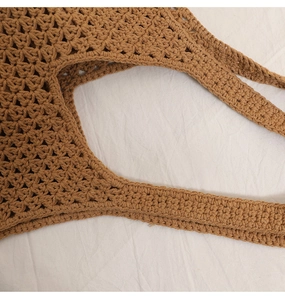 Close-up of the reinforced hand-woven cotton rope handle on the brown crochet beach bag