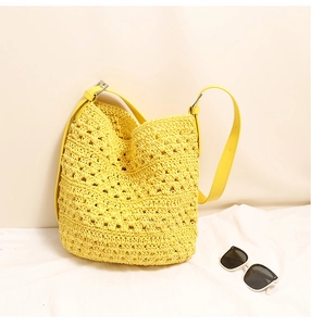 Détail du sac seau jaune tissé main avec bandoulière en cuir réglable et boucle en métal