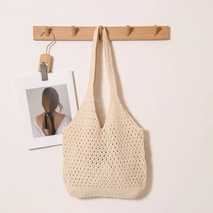 Beige crochet cotton shoulder tote bag with hollow knit texture for beach vacations
