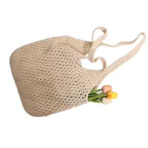 Beige hollow crochet shoulder bag made of cotton rope with decorative tulips on white background
