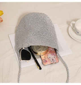 Detail of silver woven bucket bag showing spacious interior with daily essentials inside