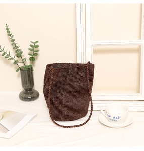 Detail view of coffee brown crochet bucket bag with fine knit texture in a lifestyle setting