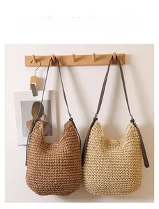 Hanging handwoven straw tote bags with faux leather straps in brown and beige colors