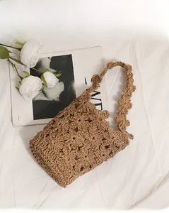 Gros plan d'un sac à bandoulière en crochet fait main avec motifs floraux ajourés marron