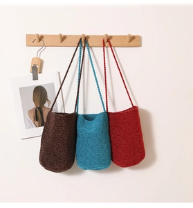 Detailed knit texture of colorful straw bucket bags hanging on a wooden wall rack