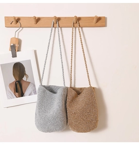 Detailed view of handmade crochet straw bucket bags with dense woven texture and long straps