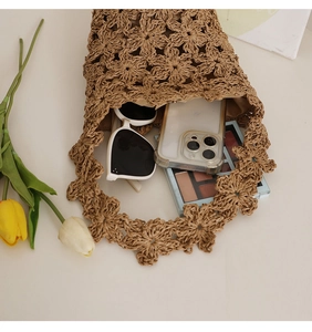 Détail du sac seau floral crocheté à la main montrant l'espace intérieur avec des accessoires