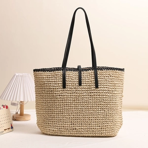 Große Strohtasche mit schwarzen Kunstlederriemen für Damen am Sommer Strandurlaub