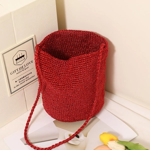 Metallic red woven straw bucket bag with a long shoulder strap for beach holidays