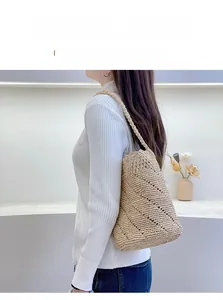 Detail of hand-woven raffia shoulder bag with intricate hollow lace texture for summer
