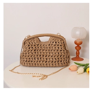 Detail of hand-woven straw bag texture with orange lamp and flowers on white table