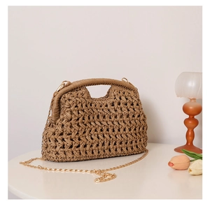 Detailed texture of thick woven rope on a brown straw bag with a delicate gold chain strap