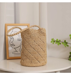 Detailed close-up of handmade raffia bucket bag showing hollow lace weaving pattern