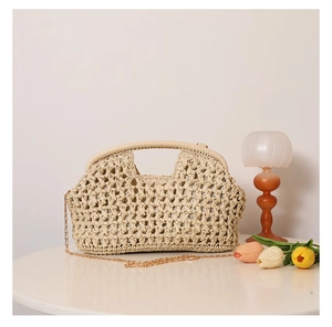 Macro detail of beige hollow woven straw bag featuring gold chain and chic texture