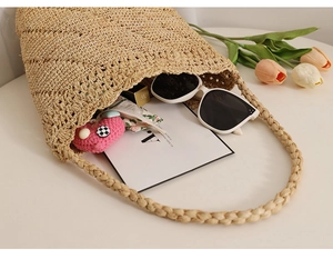 Close-up of beige raffia bucket bag interior showing capacity for sunglasses and lipstick