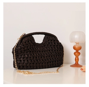 Detail of dark brown woven straw bag with wavy texture and gold metal chain strap