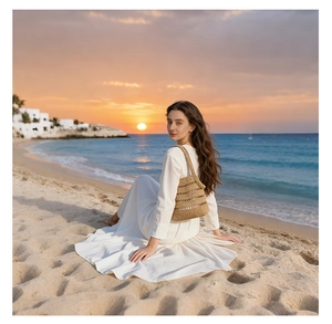 Detail of hollow woven straw shoulder bag against a sunset beach and white summer dress