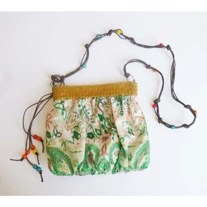 Detail of bohemian fabric crossbody bag with green vine prints and colorful beads