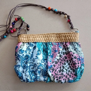 Detail of bohemian shoulder bag with mixed floral prints and colorful wooden beads