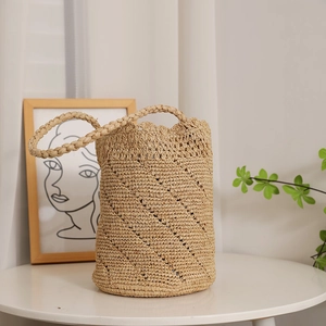 Handwoven raffia bucket bag with hollow lace design for beach vacations and summer style