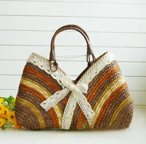 Detail of colorful woven straw handbag with white lace trim and large bow decoration
