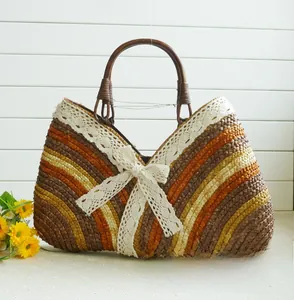 Close-up of woven straw handbag featuring earth-tone stripes and a white lace bow detail