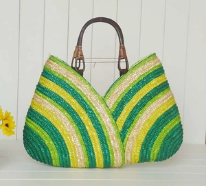 Detail of colorful striped woven straw bag with dark brown circular wooden handles