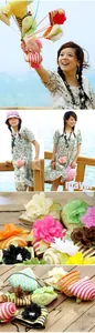 Detail of mini straw beach bags with colorful stripes and decorative 3D fabric flowers