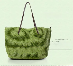 Detail view of green straw woven tote bag with brown leather handles and metal hardware