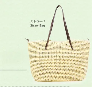 Close-up of handmade straw tote bag with cream woven texture and brown leather handles