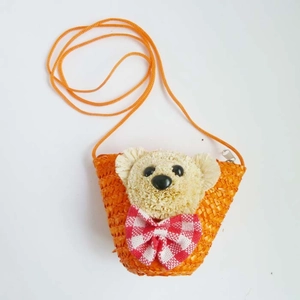 Close-up of orange woven mini bear bag with red and white checkered bow detail