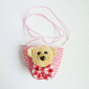 Detailed view of pink straw woven bear bag with cute bow and metal zipper closure