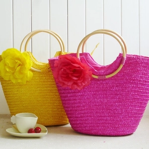 Straw floral tote bag with wooden handles in yellow and magenta for beach vacations