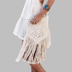 Detail of bohemian cream fringe bag featuring intricate diamond woven patterns and tassels